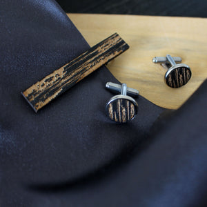 Kelo -malliston kalvosinnapit ja solmioneulan sisältävä setti, värissä musta. Käyttöyhteys harmaan kravatin kanssa.